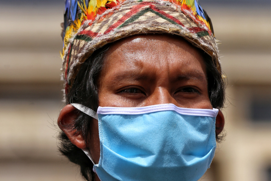 Kolumbien, Bogotá: Ein Mitglied eines indigenen Volkes trägt während einer Demonstration in Bogota eine Maske zum Schutz vor dem Coronavirus.