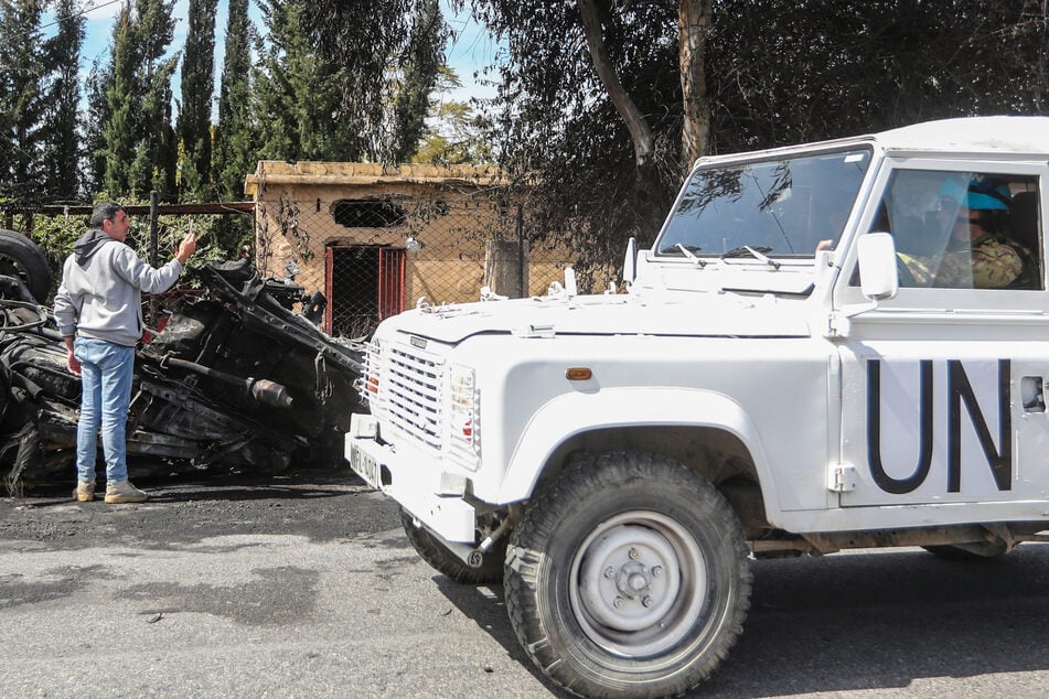 Ein Fahrzeug der UN-Friedenstruppen fährt im Libanon an einem zerstörten Auto vorbei. (Archivbild)