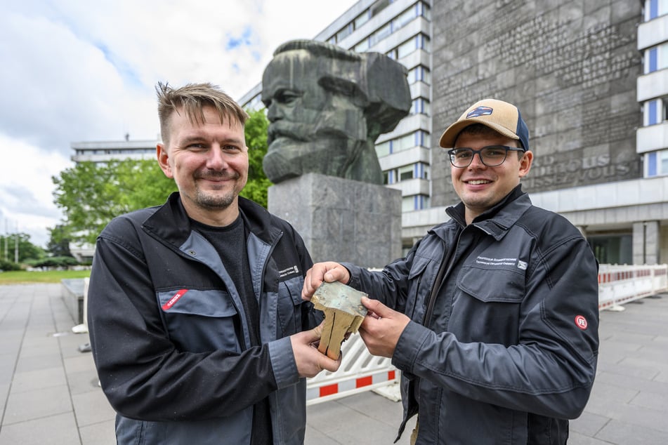 Tino Bochmann (l.) und Marvin Uhlig von der TU Chemnitz mit dem Stück "Marx-Schädel", das sie als Materialprobe entnommen haben.