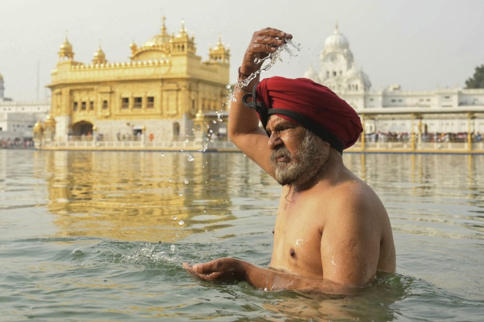 Ein Anhänger der Sikh-Religion erfrischt sich im heiligen Fluss Narmada.
