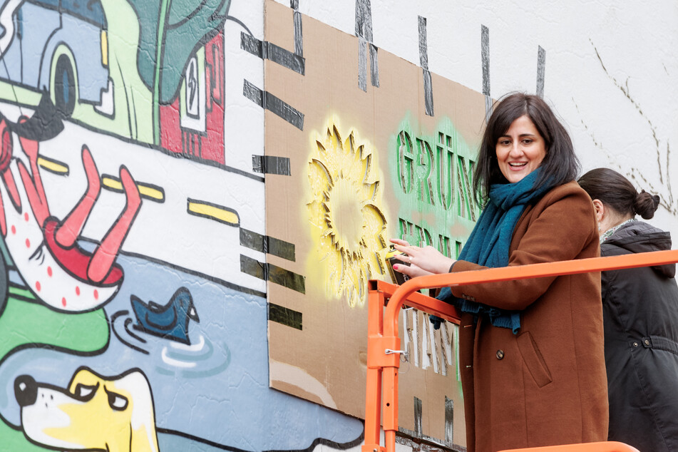 Maryam Blumenthal (38, Grüne), Hamburger Parteivorsitzende, sprüht auf einem Pressetermin zu "1000 Tage grüne Fraktionsarbeit in Hamburg" das Logo der Grünen-Fraktion auf ein Wandgemälde.