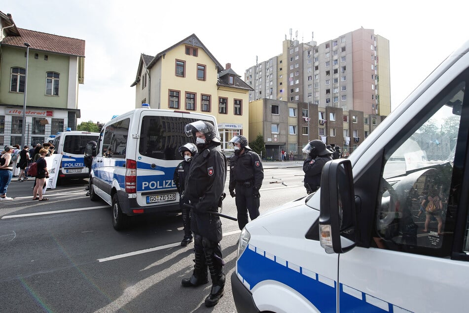 Polizisten stehen vor einem unter Quarantäne gestellten Wohngebäude in der Göttinger Innenstadt.