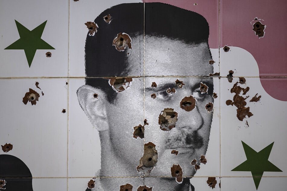 Bullet holes deface a mural depicting the toppled Syrian President Bashar al-Assad in Adra town on the northeastern outskirts of Damascus on Wednesday.