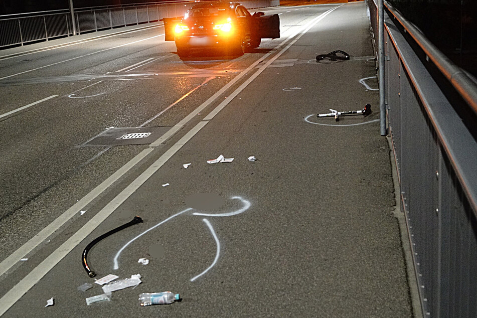 Unter anderem liegen Teile des Fahrrads auf der Straße verteilt.