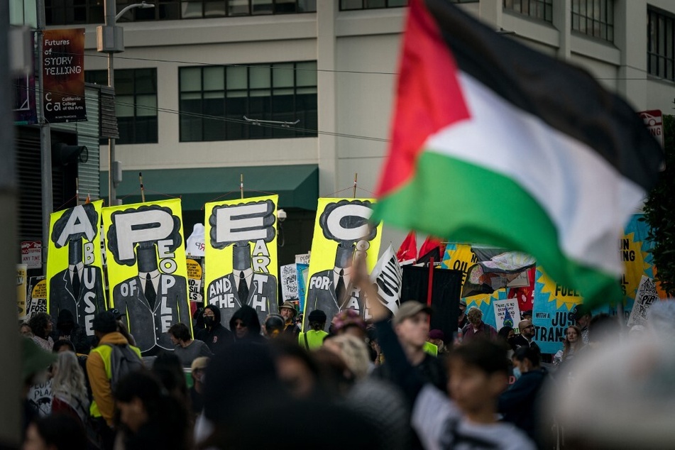 Protesters of the Asia-Pacific Economic Cooperation global trade summit wave Palestinian flags as they march toward the Moscone Center on November, 12, 2023, in San Francisco, California.