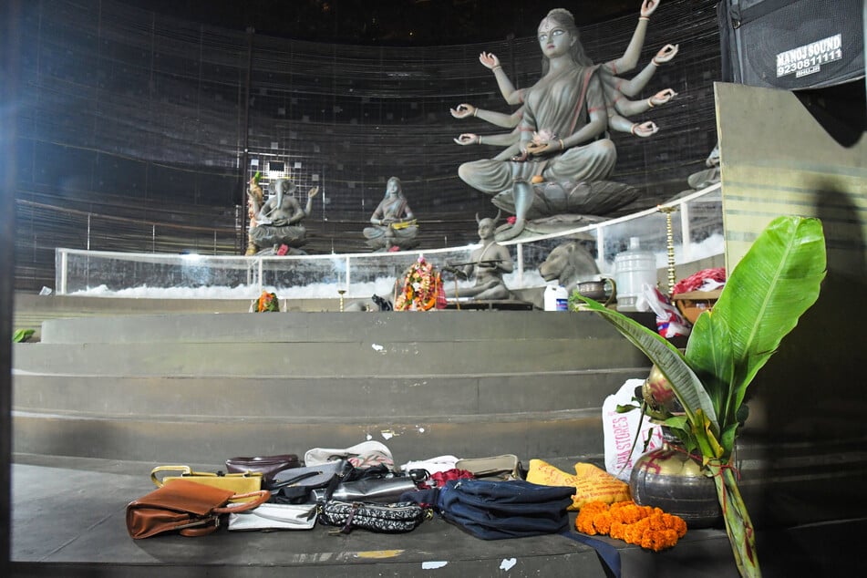 Geldbörsen und andere Gegenstände, die von Gläubigen zurückgelassen wurden, liegen nach einer Massenpanik auf dem Boden einer Kultstätte für das hinduistische Durga-Puja-Fest.