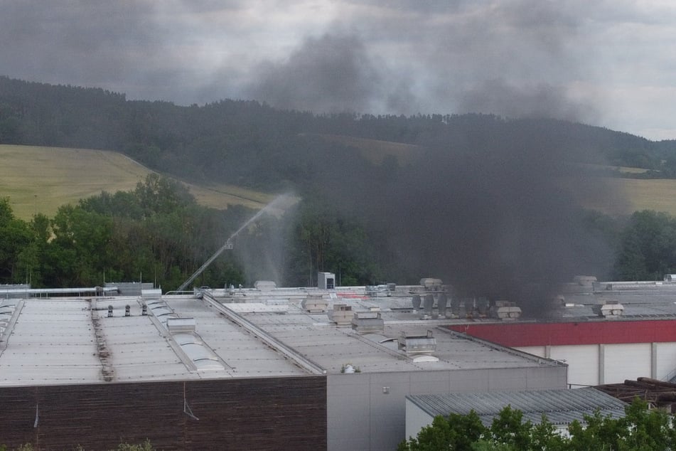 Schwarzer Rauch schwebt über der Werkshalle.