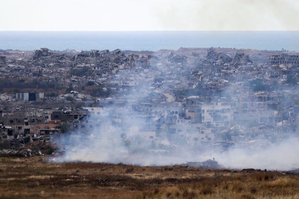 This picture taken from Israel's southern border shows burning fields in front of destroyed houses in northern Gaza on May 4, 2025.