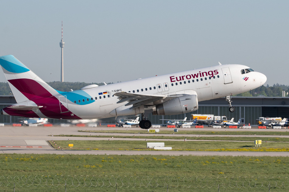 Ein Flugzeug der Eurowings startet auf dem Flughafen Stuttgart, im Hintergrund ist der Fernsehturm zu sehen.