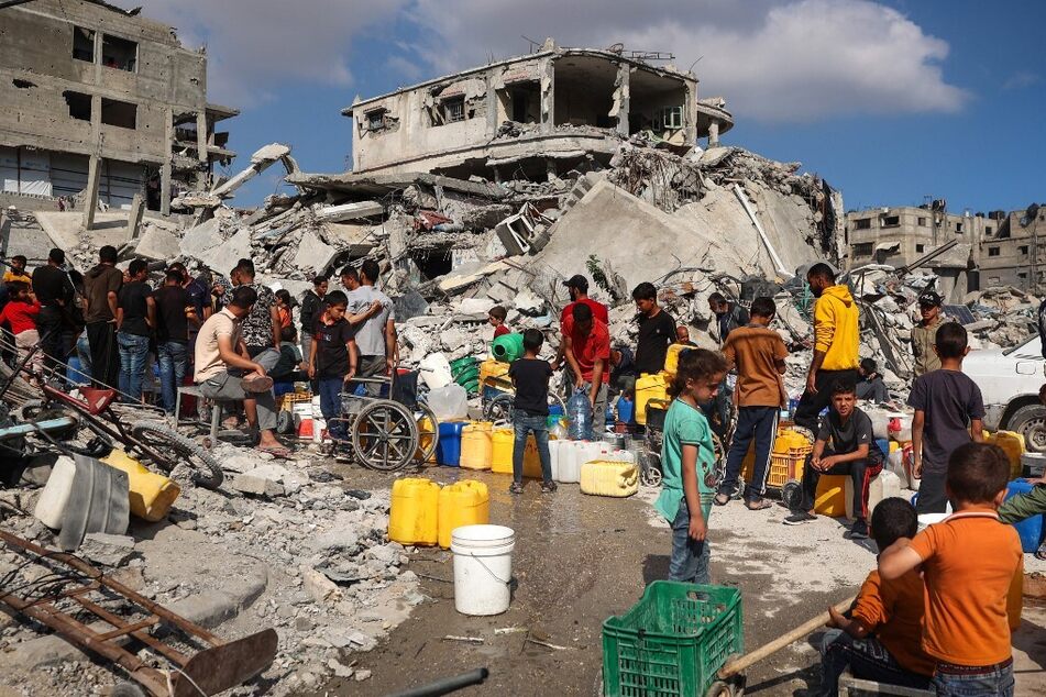 Displaced Palestinians gather at a water point to fill their jerrycans in Khan Younis in the southern Gaza Strip.