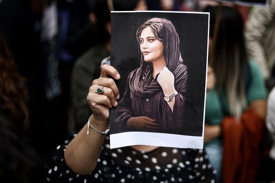 A protester holds a portrait of Mahsa Amini, a 22-year-old Kurdish woman who died in police custody after allegedly violating Islamic dress codes.