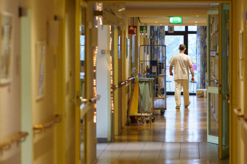 Ein Pfleger geht den Gang eines Pflegeheims entlang. Aufgrund von Corona-Infektionen unter dem Personal spitzt sich die Lage in vielen Brandenburger Einrichtungen zu. (Symbolfoto)