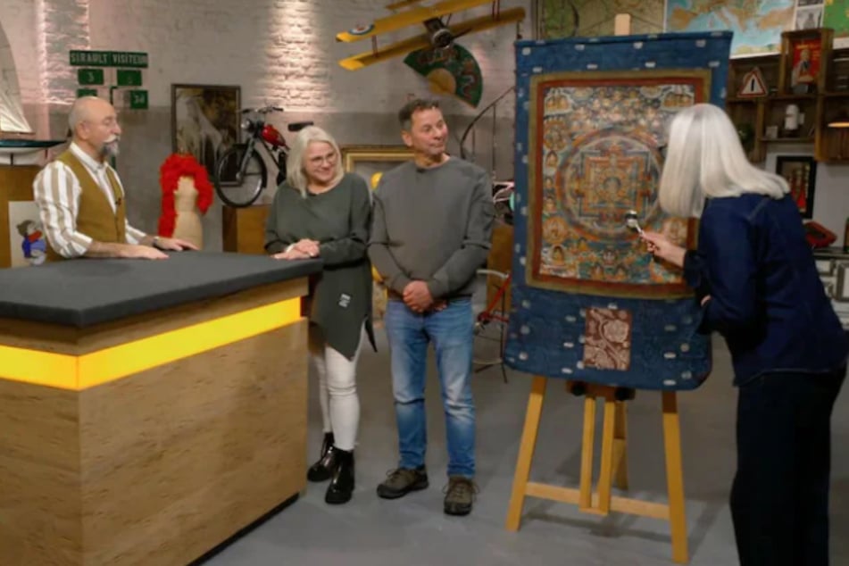 Heike und Joachim (M.) wollen bei "Bares für Rares" einen Wandteppich verkaufen, der sich als sogenanntes Thangka entpuppt.