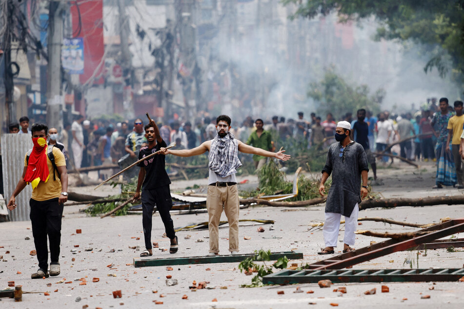 A demonstrator gestures as Border Guard Bangladesh and police officers crack down on student-led anti-quota protests in Dhaka.