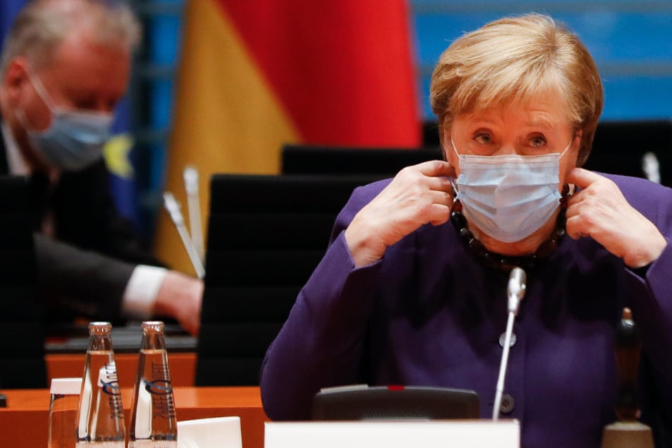Bundeskanzlerin Angela Merkel nimmt ihre Gesichtsmaske ab, als sie zur wöchentlichen Kabinettssitzung der Bundesregierung im Kanzleramt eintrifft.