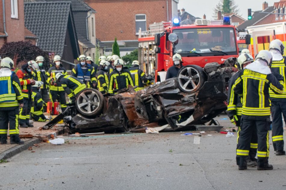 Feuerwehrleute begutachten das völlig demolierte Fahrzeug.