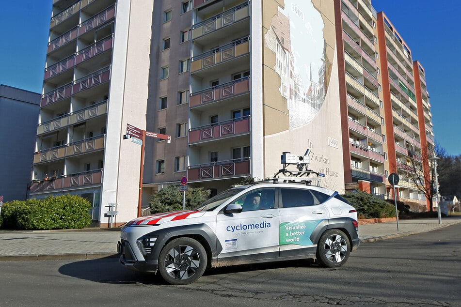 Ein weißer Hyundai mit auffälligem Dachaufbau im Zwickauer Stadtzentrum: Das Videocar erfasst mit 360-Grad-Kameras den Straßenraum für digitale Kartendaten.