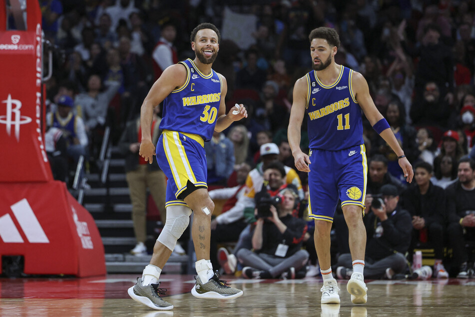 Golden State Warriors guard Stephen Curry, alongside guard Klay Thompson, reacts after making a basket during the fourth quarter against the Houston Rockets at Toyota Center.