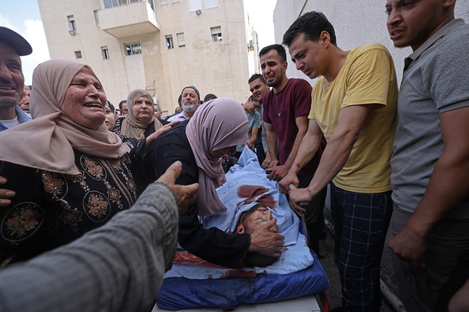 Mourners weep over the body of a slain Palestinian man at a hospital in Nablus in the occupied West Bank on July 24, 2026.