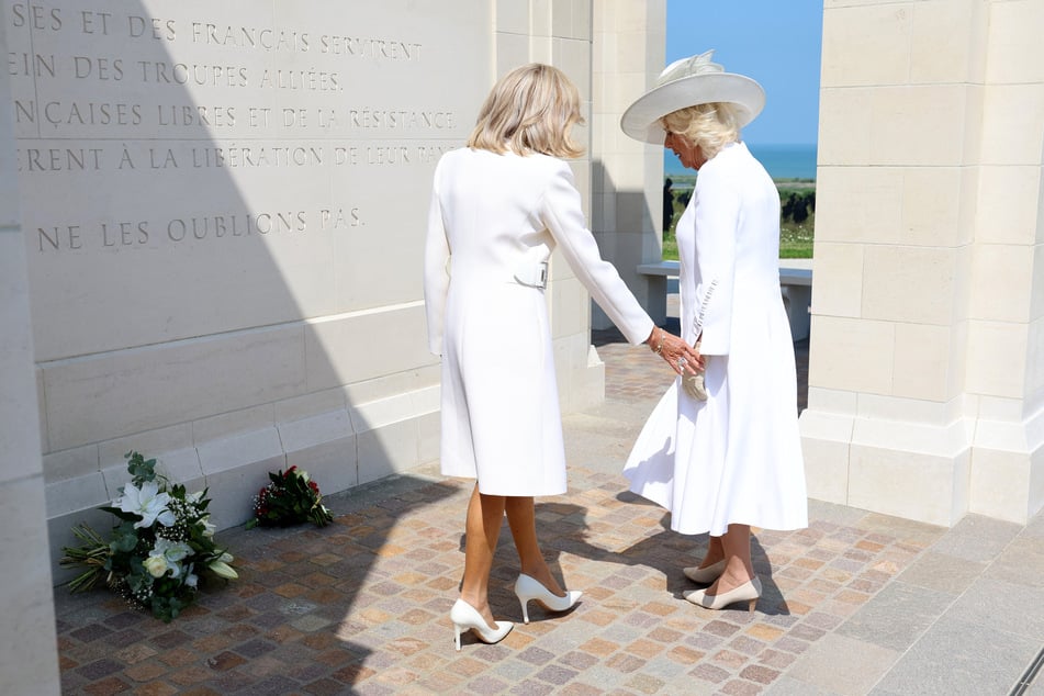 Aufnahmen zeigen, wie Brigitte Macron (71, l.) die Initiative ergreift und die Hand von Camilla (76, r.) berührt.