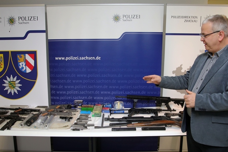 Ein Kriminalbeamter zeigt einen Teil der gefundenen Waffen und Munition.