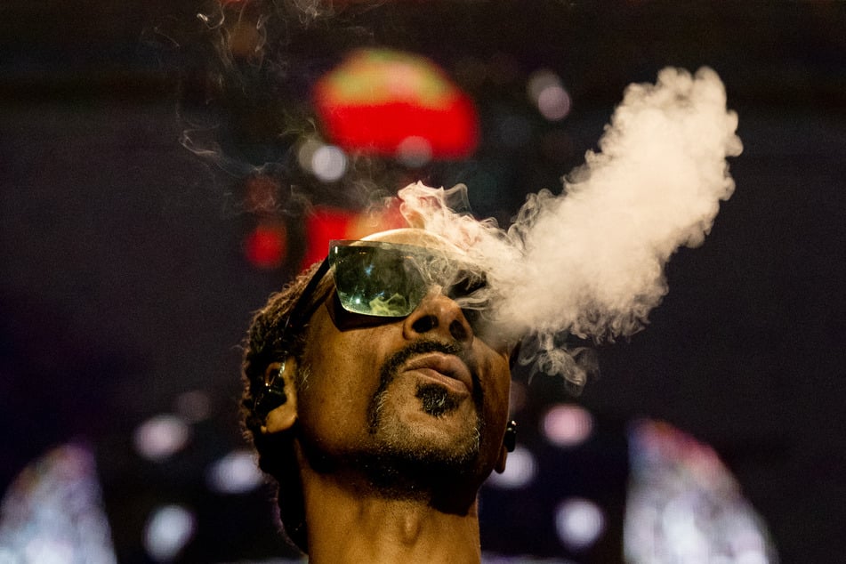 Rapper Snoop Dogg blows smoke as he performs on stage at the Accor Arena of Bercy, in Paris, on March 25, 2023.