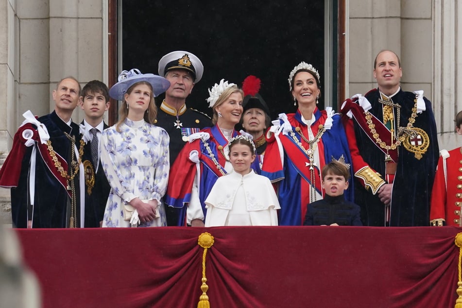 Die britische Königsfamilie steht nach der Zeremonie in Westminster Abbey auf dem Balkon des Buckingham Palace. Prinz Louis (5, vorne r.) schneidet Grimassen.