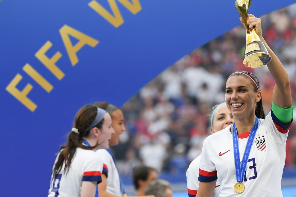 US-Kapitänin Alex Morgan (r.) jubelt 2019 nach dem WM-Triumph mit dem Pokal.