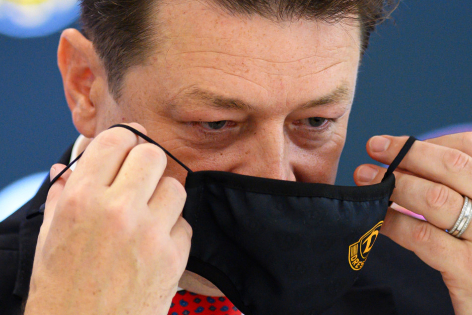 Maske auf! Holger Scholze zieht sich einen Mund-Nasen-Schutz über - natürlich im Dynamo-Design.