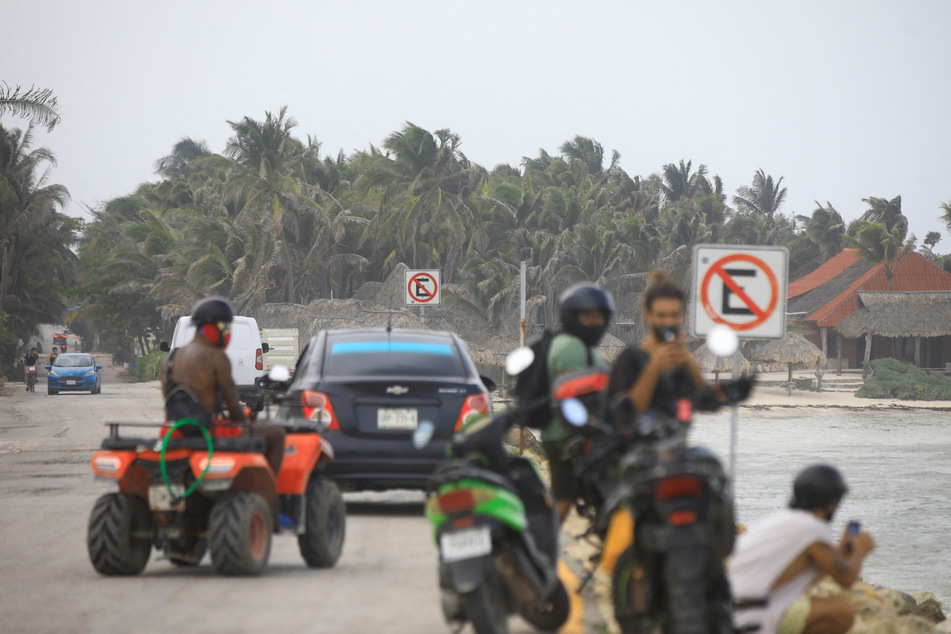 People are pictured near a beach in Tulum, Mexico, ahead of the arrival of Hurricane Beryl.