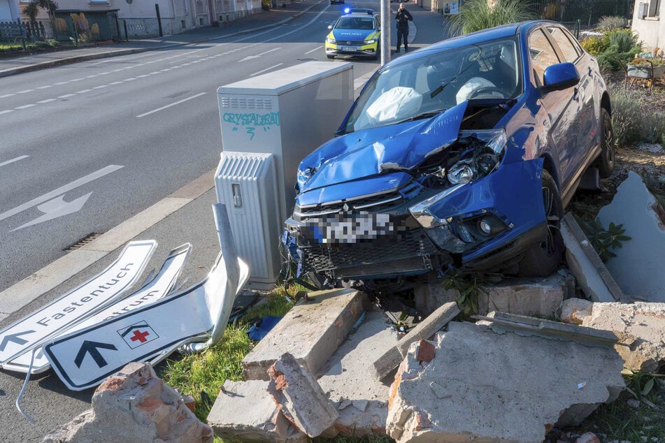 Das Fahrzeug durchbrach eine Mauer und einen Zaun, nachdem es mit einem Verkehrsschild kollidiert war.