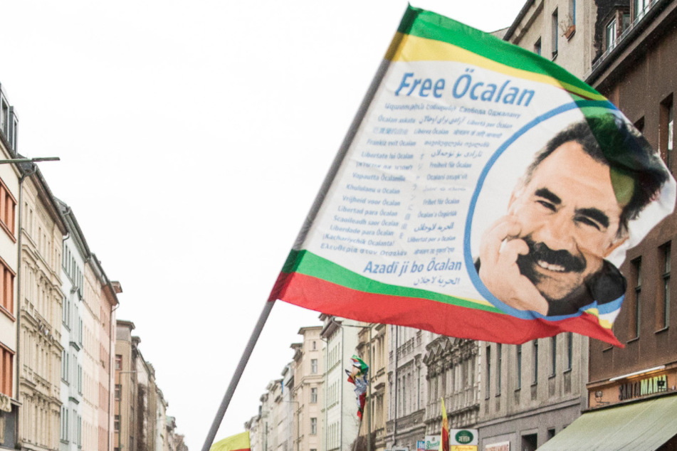 Bei einer Demonstration in Berlin schwenken Demonstranten eine Fahne mit dem Konterfei von Abdullah Öcalan, dem Führer der verbotenen Kurdischen Arbeiterpartei PKK. Die Generalstaatsanwaltschaft hat Anklage gegen ein mutmaßliches PKK-Mitglied erhoben. (Symbolbild)