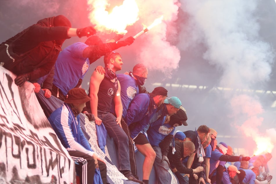 Anhänger vom FC Hansa Rostock feiern den Aufstieg ihrer Mannschaft mit Pyrotechnik.