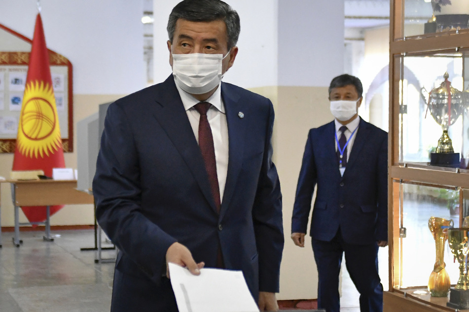 Kirgistan, Bischkek: Sooronbaj Dscheenbekow, Präsident von Kirgistan, gibt im einem Wahllokal seine Stimme ab. Sein Gesicht ist mit einer Mund-Nasen-Schutzmaske bedeckt.