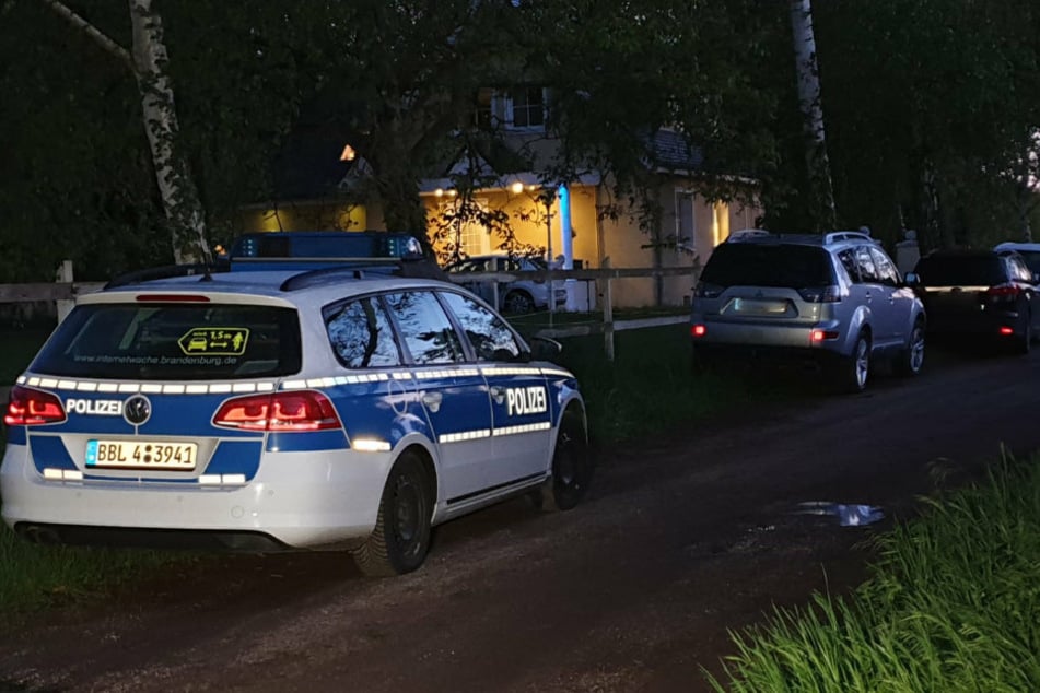 Ein Polizeiauto steht vor dem Haus in Werder (Havel).