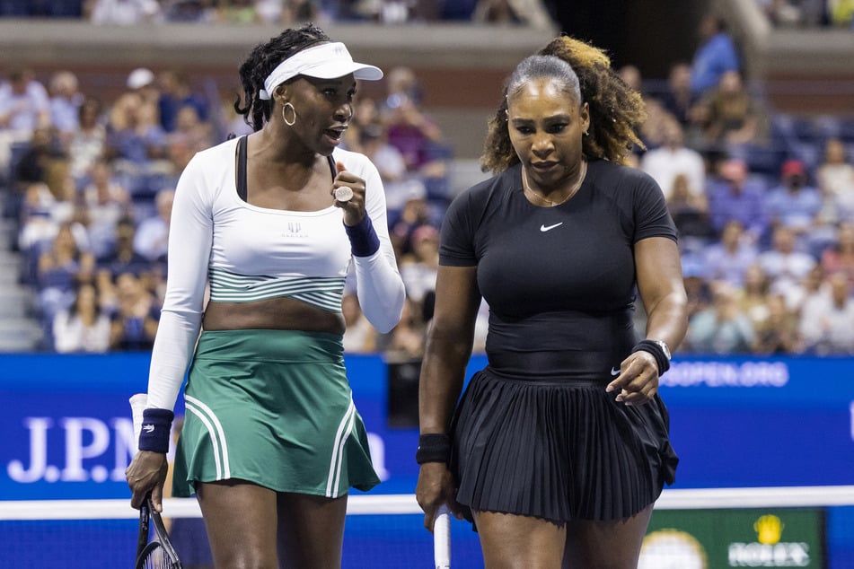 Serena (r.) and Venus Williams confer as they play against Czech Republic's Lucie Hradecka and Linda Noskova during their 2022 US Open Tennis tournament women's doubles first round match in New York, on September 1, 2022.