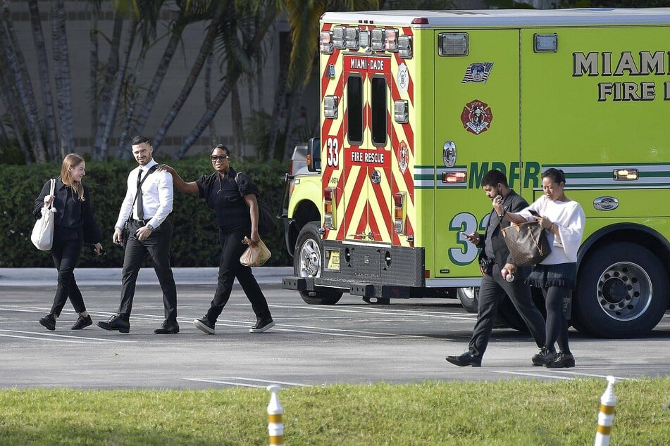 Aventura Mall employees are escorted away by police.