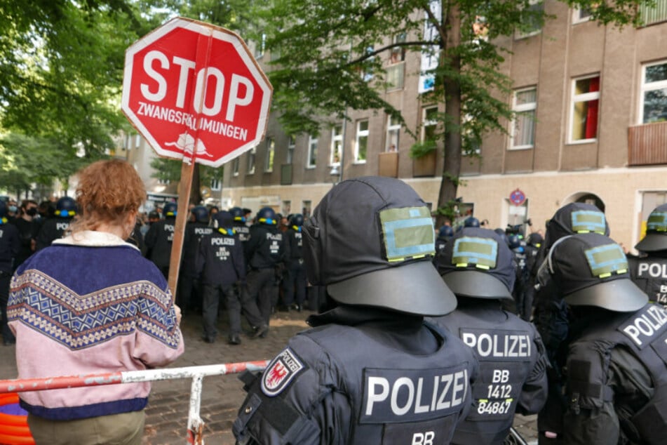 Polizisten stehen am Freitagmorgen in der Weisestraße vor und hinter den Absperrgittern.