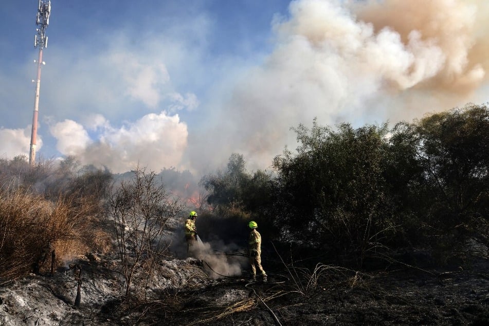 Israeli first responders put out a fire in an open area in Lod near Tel Aviv, reportedly caused by a missile fired from Yemen.