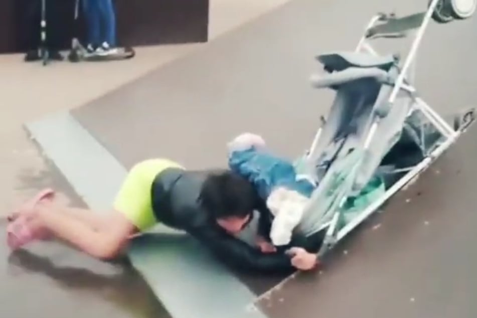Alle Versuche, über die Rampe zu kommen, gingen schief. Am Ende stürzte die Frau zu Boden und riss den Kinderwagen samt Baby um.