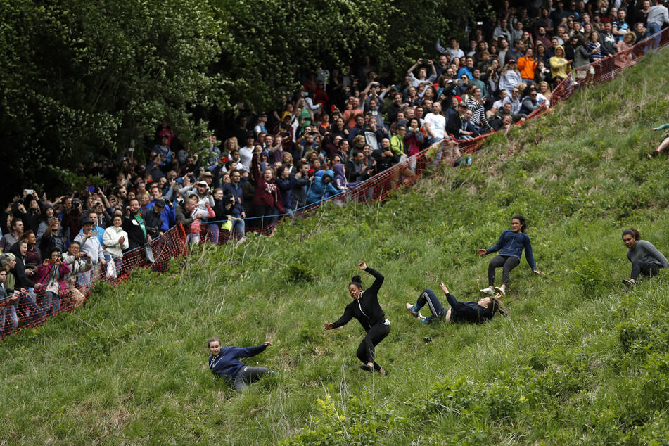 Women racing down Cooper's Hill in the UK after a wheel of cheese in the annual cheese rolling competition.