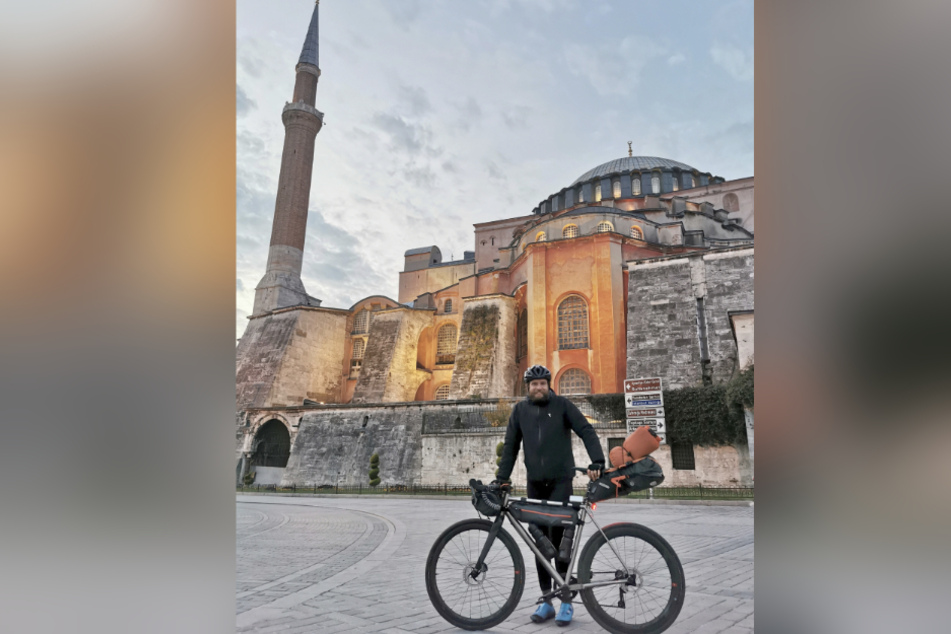 Extremsportler Jonas Deichmann (33) steht mit seinem Fahrrad vor einer Moschee in Istanbul.