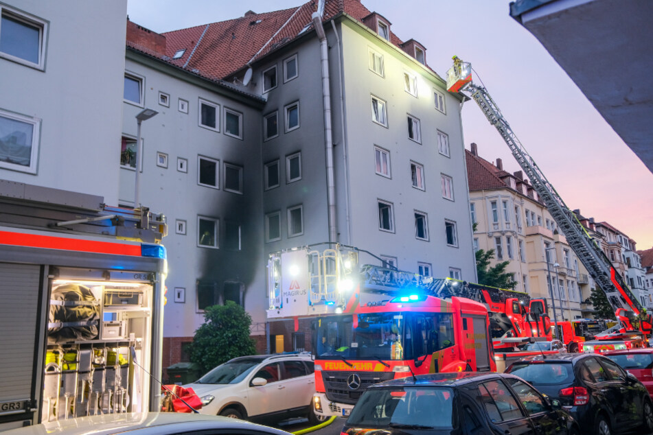 Feuerwehrleute kontrollieren nach der Explosion in einer Wohnung das gesamte Mehrfamilienhaus in Hannover.