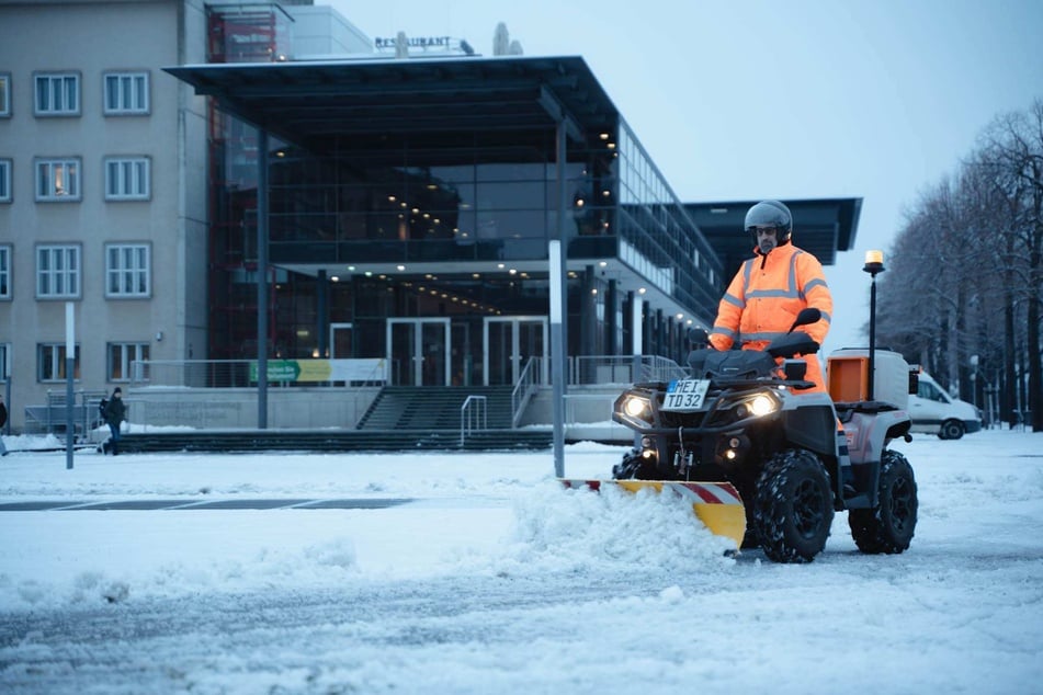 Am Dresdner Landtag ist ein Quad angerückt, um den Schnee wegzuräumen.