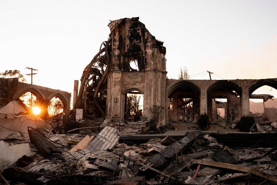 The sun sets behind the remains of a church destroyed by the Palisades Fire in the Pacific Palisades neighborhood in Los Angeles, California, on January 11, 2025.