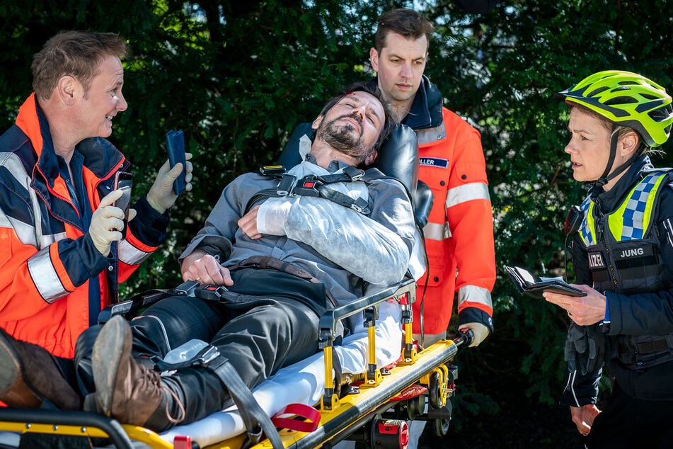 Dr. Haase (Fabian Harloff, l.) berichtet Franzi (Rhea Harder-Vennewald, r.), dass sein Patient Ole Kern (René Geisler, M.) von hinten niedergeschlagen wurde.