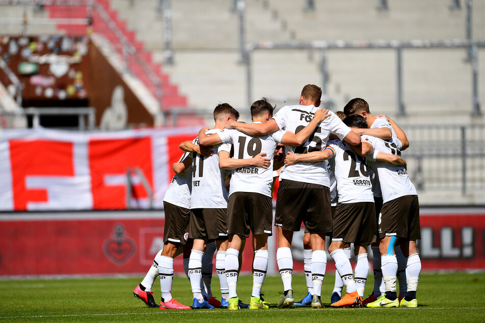 Die Spieler von Pauli stehen vor einem Spiel zusammen.