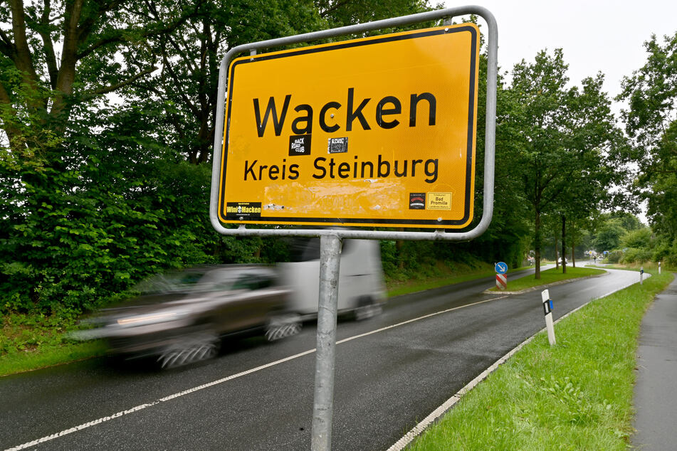 Ein Auto fährt am Ortsschild von Wacken vorbei.