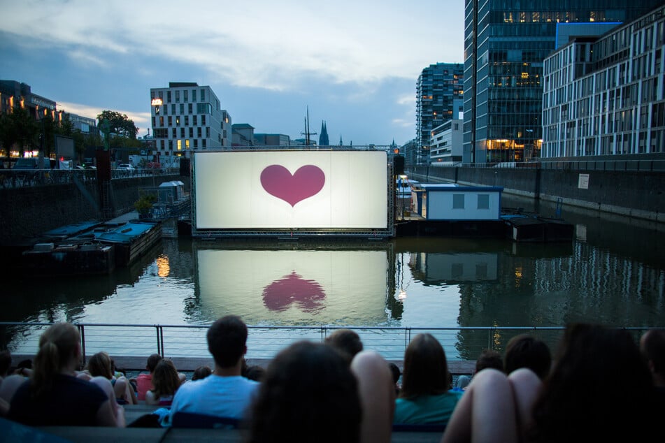 Im Open-Air-Kino am Rheinauhafen vor der Domkulisse in Köln könnt ihr noch bis Mitte September Filme in gemütlicher Freilicht Atmosphäre schauen. (Archivbild)