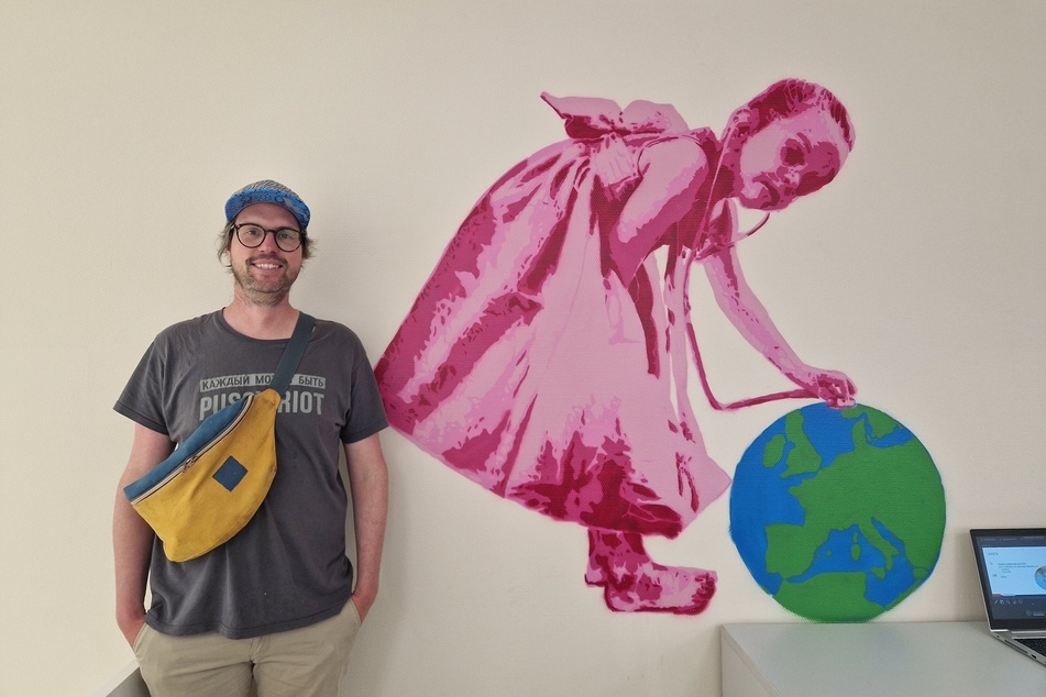 Künstler Lapiz neben einem seiner zwei im Impfzentrum vertretenen Kunstwerke. Das Mädchen mit der Weltkugel war ursprünglich eine Auftragsarbeit für einen Kindergarten gewesen.